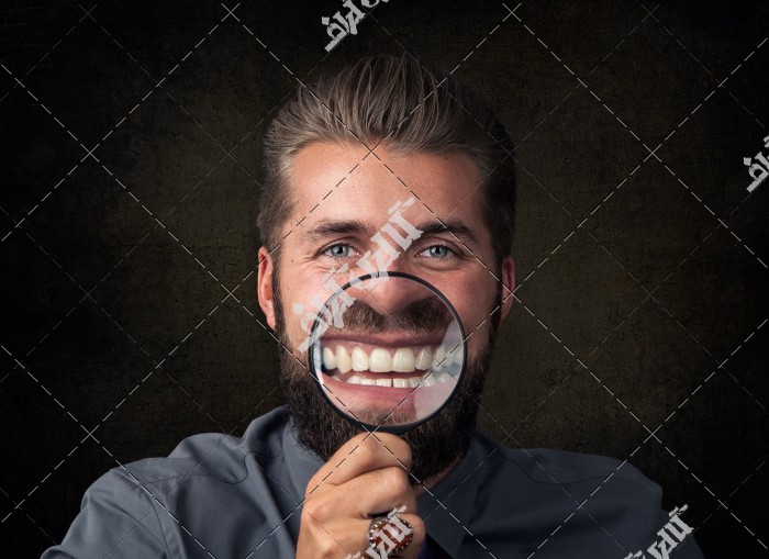 عکس مرد با دندان های سفید و ذره بین