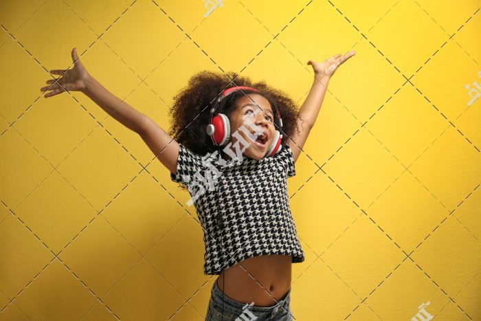 کودک خوشحال در حال گوش دادن به موسیقی با هدفون