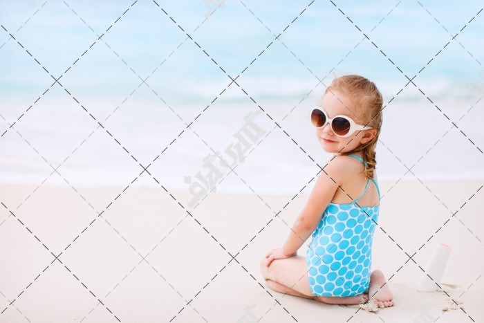 دختربچه با مایو آبی در ساحل دریا