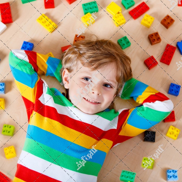 پسربچه با لباس رنگی و اسباب بازی