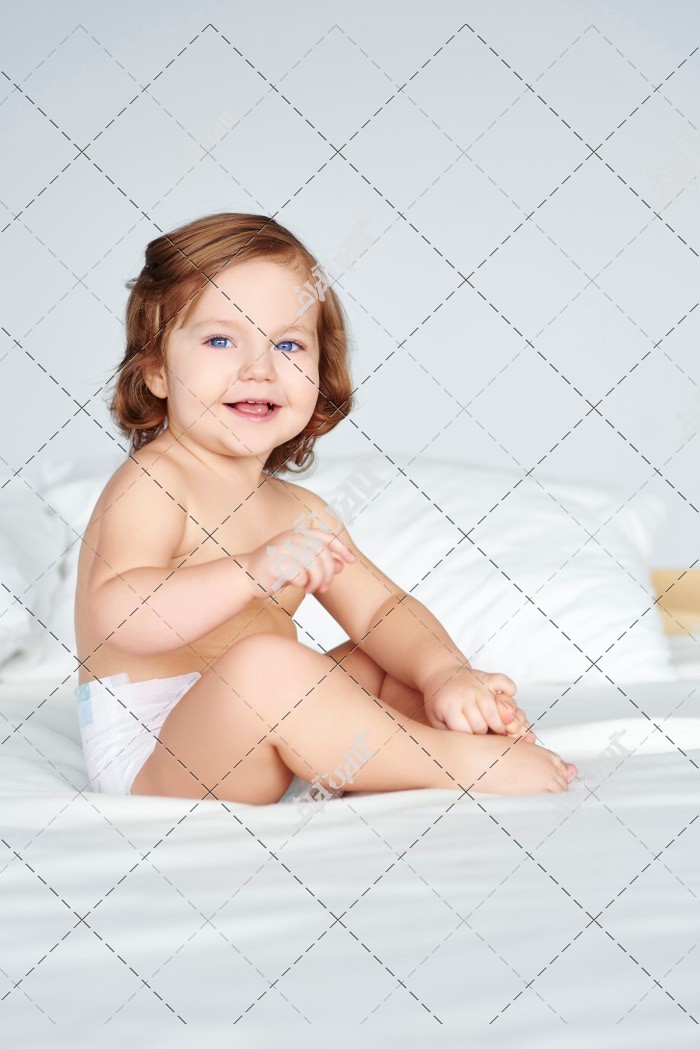 عکس کودک با پوشک روی تخت