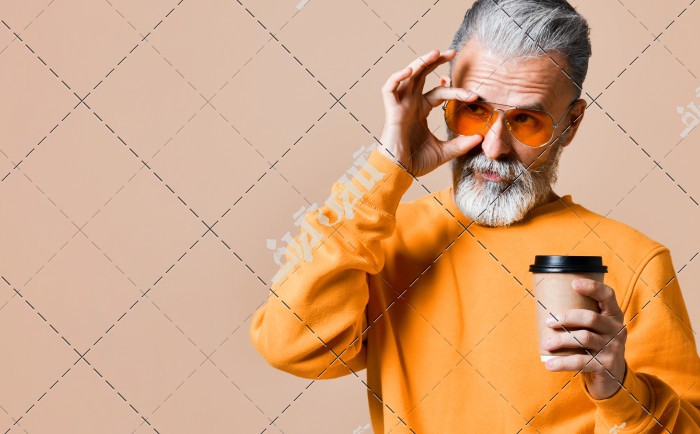 تصویر پیرمرد که درحال زدن عینک دودی می باشد