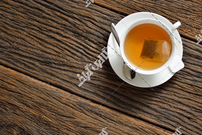تصویر یک فنجان چای روی میز چوبی