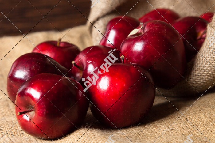 تصویر چند سیب قرمز و تازه داخل گونی