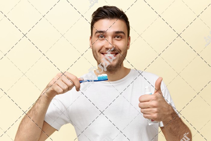 مرد جوان در حال مسواک زدن و شستن دهان و دندان