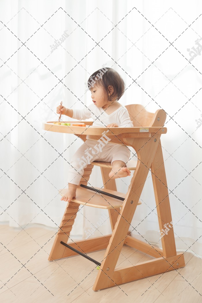 دانلود تصویر با کیفیت کودک در حال غذا خوردن روی صندلی چوبی