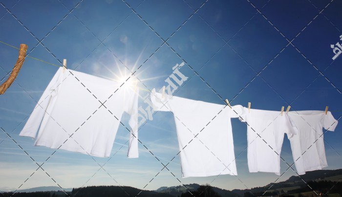 تصویر طناب و گیره لباس های خیس زیر نور آفتاب